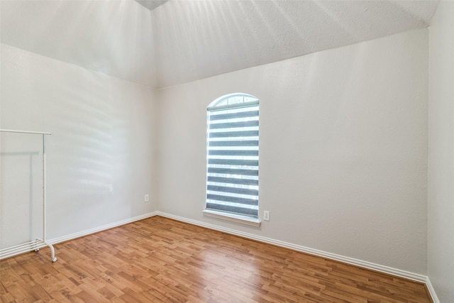 empty room with hardwood / wood-style floors and a textured ceiling