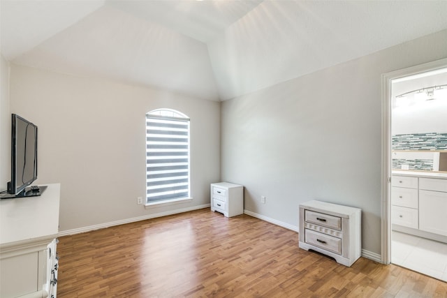 interior space with light hardwood / wood-style flooring and vaulted ceiling