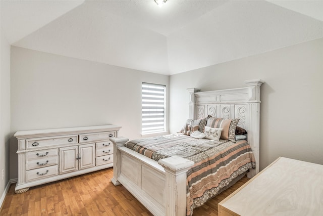 bedroom featuring light hardwood / wood-style floors and vaulted ceiling