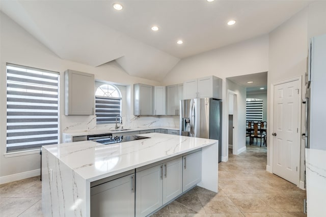 kitchen featuring gray cabinetry, a center island, light stone counters, vaulted ceiling, and black electric cooktop