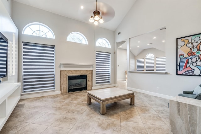 tiled living room featuring a tile fireplace, ceiling fan, and high vaulted ceiling