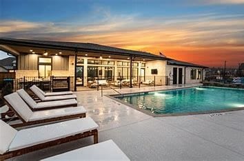 pool at dusk with a patio area