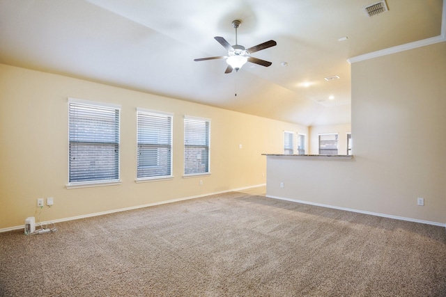 carpeted empty room featuring ceiling fan, a healthy amount of sunlight, and vaulted ceiling