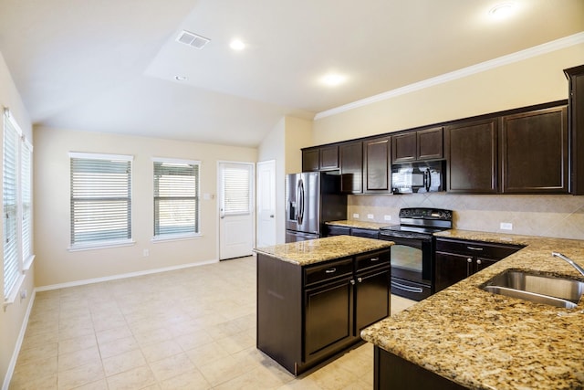 kitchen with light stone countertops, sink, lofted ceiling, a kitchen island, and black appliances