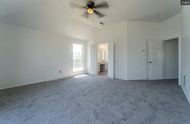 unfurnished bedroom featuring light colored carpet, vaulted ceiling, ceiling fan, and ensuite bathroom