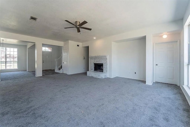 unfurnished living room with carpet, ceiling fan, and a fireplace