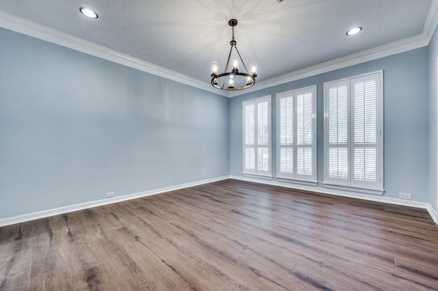 empty room featuring a notable chandelier, wood-type flooring, and ornamental molding