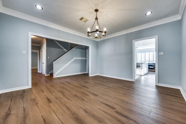 unfurnished room with dark hardwood / wood-style flooring, an inviting chandelier, and ornamental molding