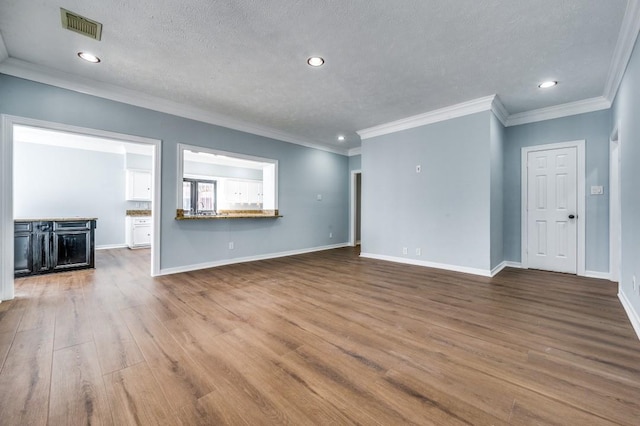 unfurnished living room featuring hardwood / wood-style flooring, ornamental molding, and a textured ceiling