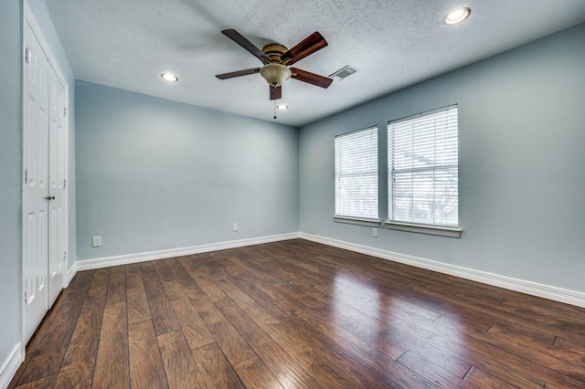 unfurnished room with a textured ceiling, ceiling fan, and dark wood-type flooring