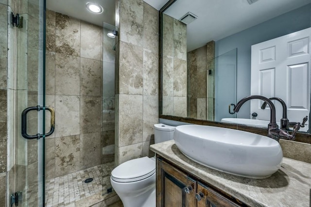 bathroom featuring an enclosed shower, vanity, toilet, and tile walls