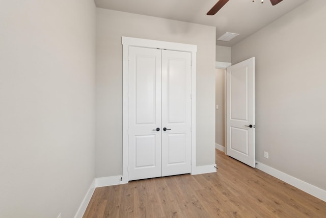 unfurnished bedroom featuring ceiling fan, a closet, and light hardwood / wood-style flooring