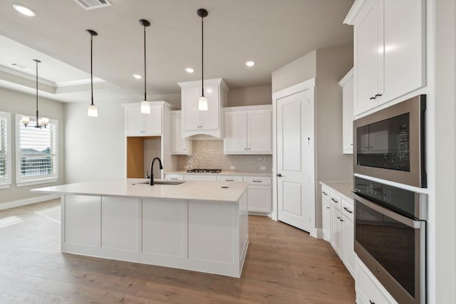 kitchen featuring oven, white cabinetry, and sink