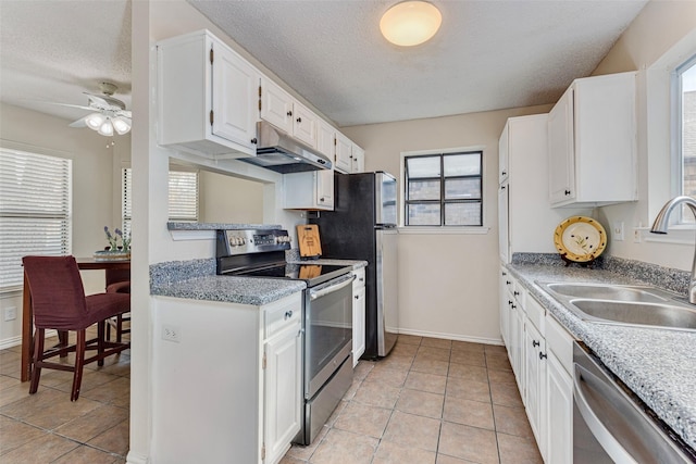 kitchen featuring white cabinets, a textured ceiling, stainless steel appliances, and sink