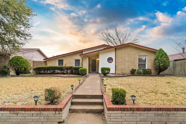 ranch-style home featuring a lawn