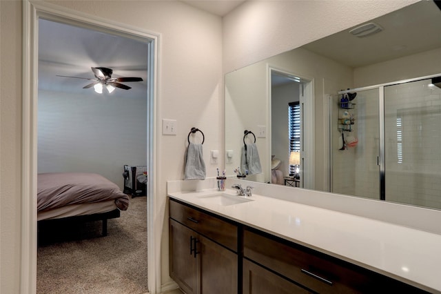 bathroom with vanity, ceiling fan, and a shower with shower door