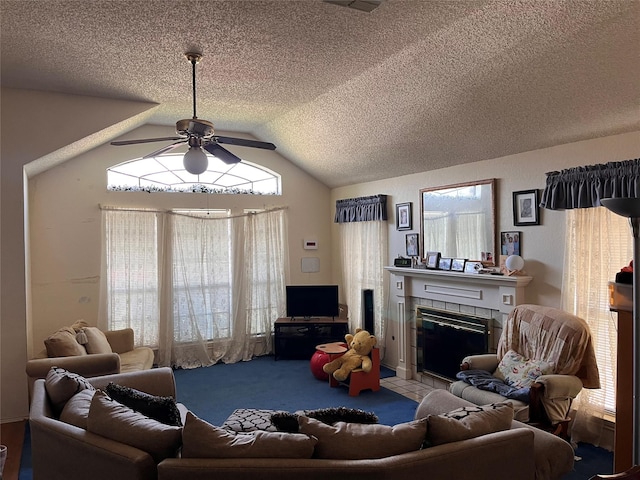 living room with ceiling fan, plenty of natural light, lofted ceiling, and a tiled fireplace