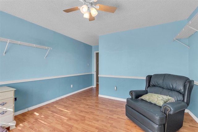 sitting room with a textured ceiling, ceiling fan, and light hardwood / wood-style floors