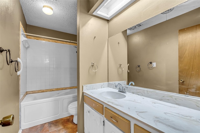 full bathroom featuring toilet, vanity, tiled shower / bath combo, a skylight, and a textured ceiling