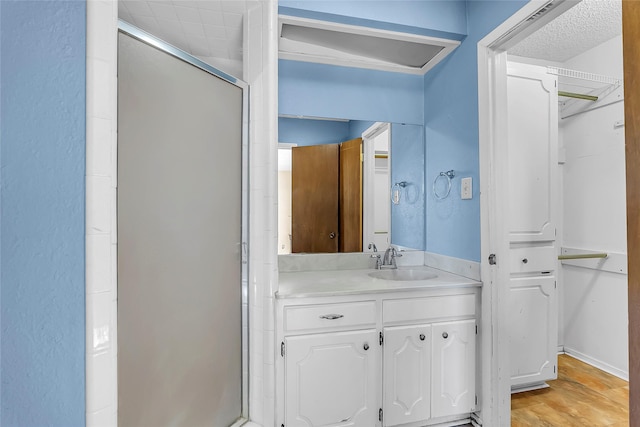 bathroom with a shower with shower door and vanity