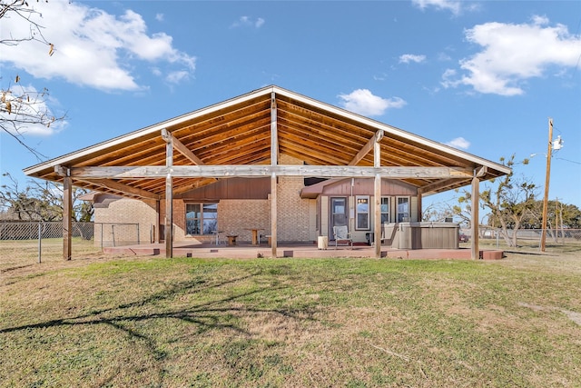 view of community featuring a patio area, a hot tub, and a yard