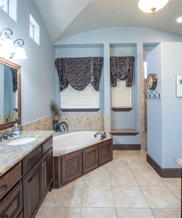 bathroom featuring tile patterned flooring, a bathtub, vanity, and vaulted ceiling