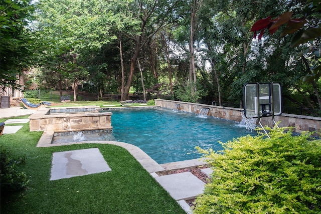 view of pool with pool water feature, a hot tub, and a yard