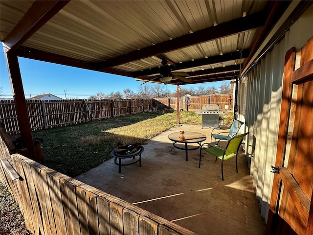 view of patio with ceiling fan and an outdoor fire pit