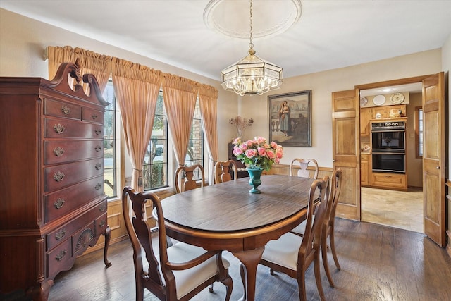 dining area featuring dark hardwood / wood-style flooring and a chandelier