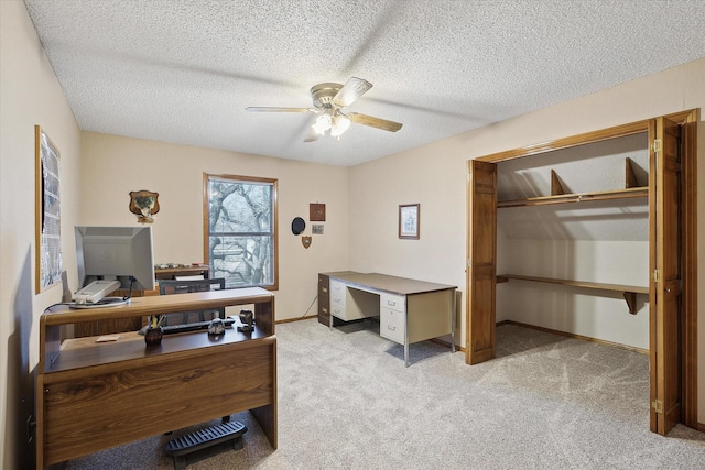 office area featuring a textured ceiling, ceiling fan, and light colored carpet