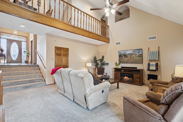 living room with high vaulted ceiling, light colored carpet, and ceiling fan