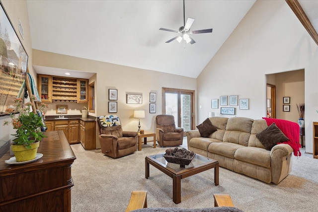 living room featuring ceiling fan, indoor bar, light colored carpet, and high vaulted ceiling