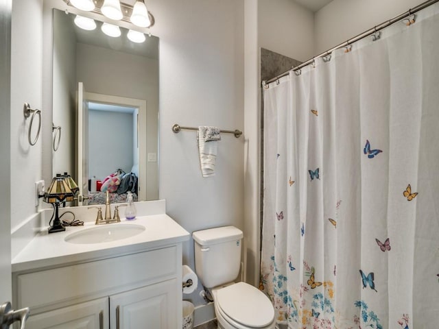 bathroom with walk in shower, vanity, and toilet