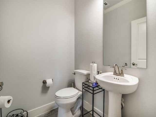 bathroom with tile patterned floors, toilet, ornamental molding, and sink