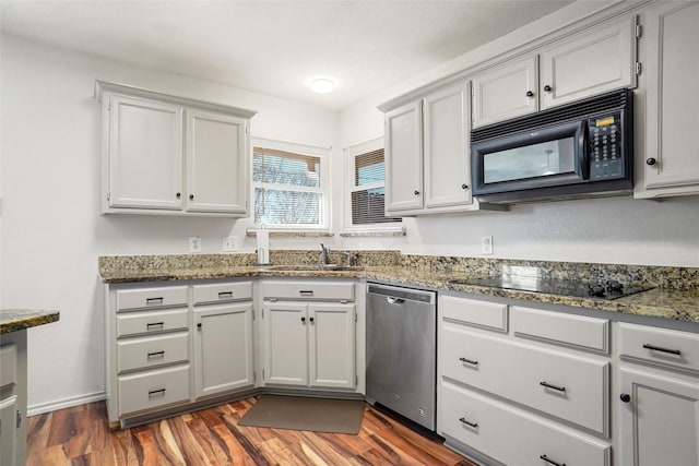 kitchen with sink, dark hardwood / wood-style flooring, dark stone countertops, gray cabinets, and black appliances