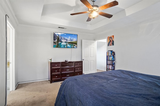 bedroom with ceiling fan, ornamental molding, light carpet, and a tray ceiling