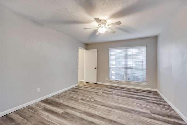 spare room featuring ceiling fan, light hardwood / wood-style floors, and a textured ceiling