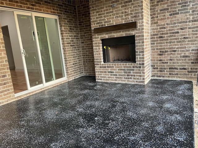 unfurnished living room featuring brick wall