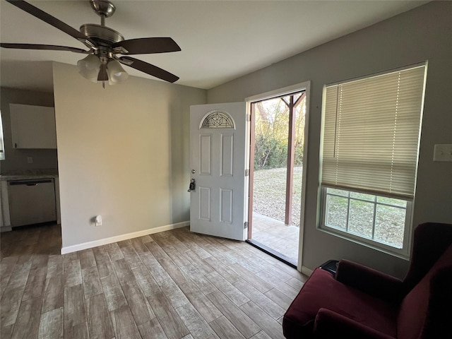 foyer entrance with ceiling fan and light wood-type flooring