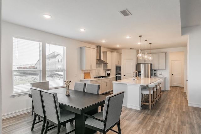 dining room featuring hardwood / wood-style flooring, a healthy amount of sunlight, and sink