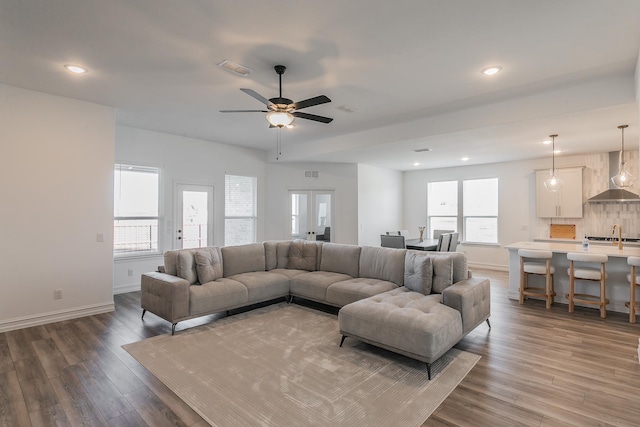 living room with hardwood / wood-style floors, ceiling fan, sink, and french doors