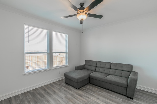 living room featuring light hardwood / wood-style flooring, ceiling fan, and ornamental molding