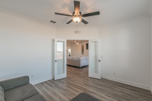 unfurnished room featuring french doors, hardwood / wood-style flooring, ceiling fan, and crown molding