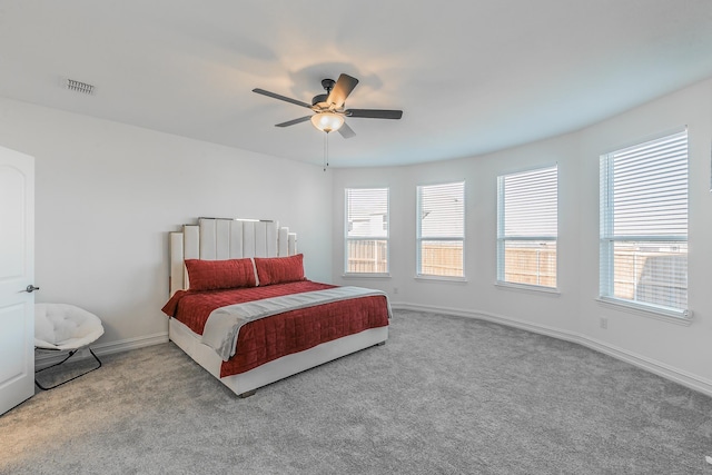 carpeted bedroom with multiple windows and ceiling fan