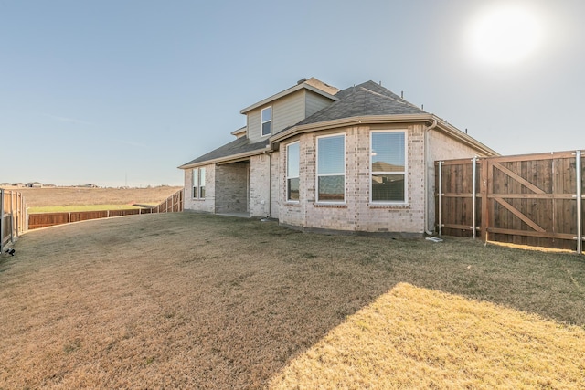 rear view of house featuring a yard