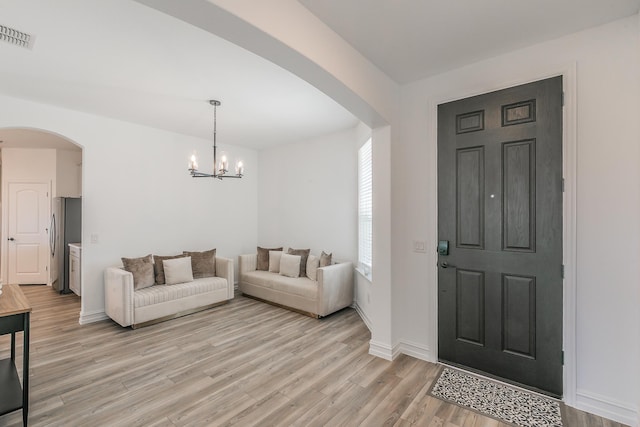 foyer featuring light hardwood / wood-style flooring and an inviting chandelier