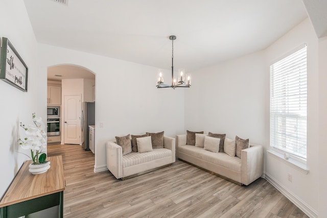 living room featuring light hardwood / wood-style flooring and an inviting chandelier