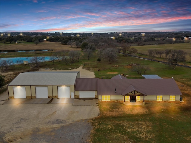 aerial view at dusk featuring a water view