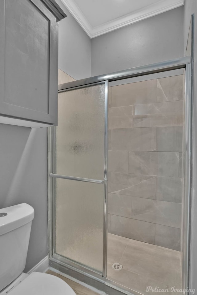 bathroom featuring toilet, ornamental molding, and walk in shower