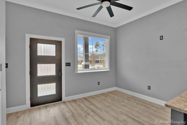 foyer with light wood-type flooring, ceiling fan, and crown molding